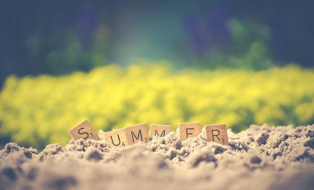 summer spelled-out in Scrabble tiles, in the sand